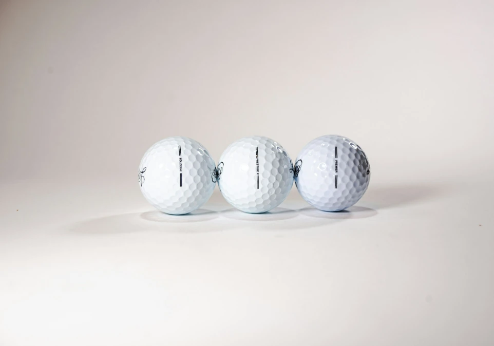 three white golf balls lined up in a row
